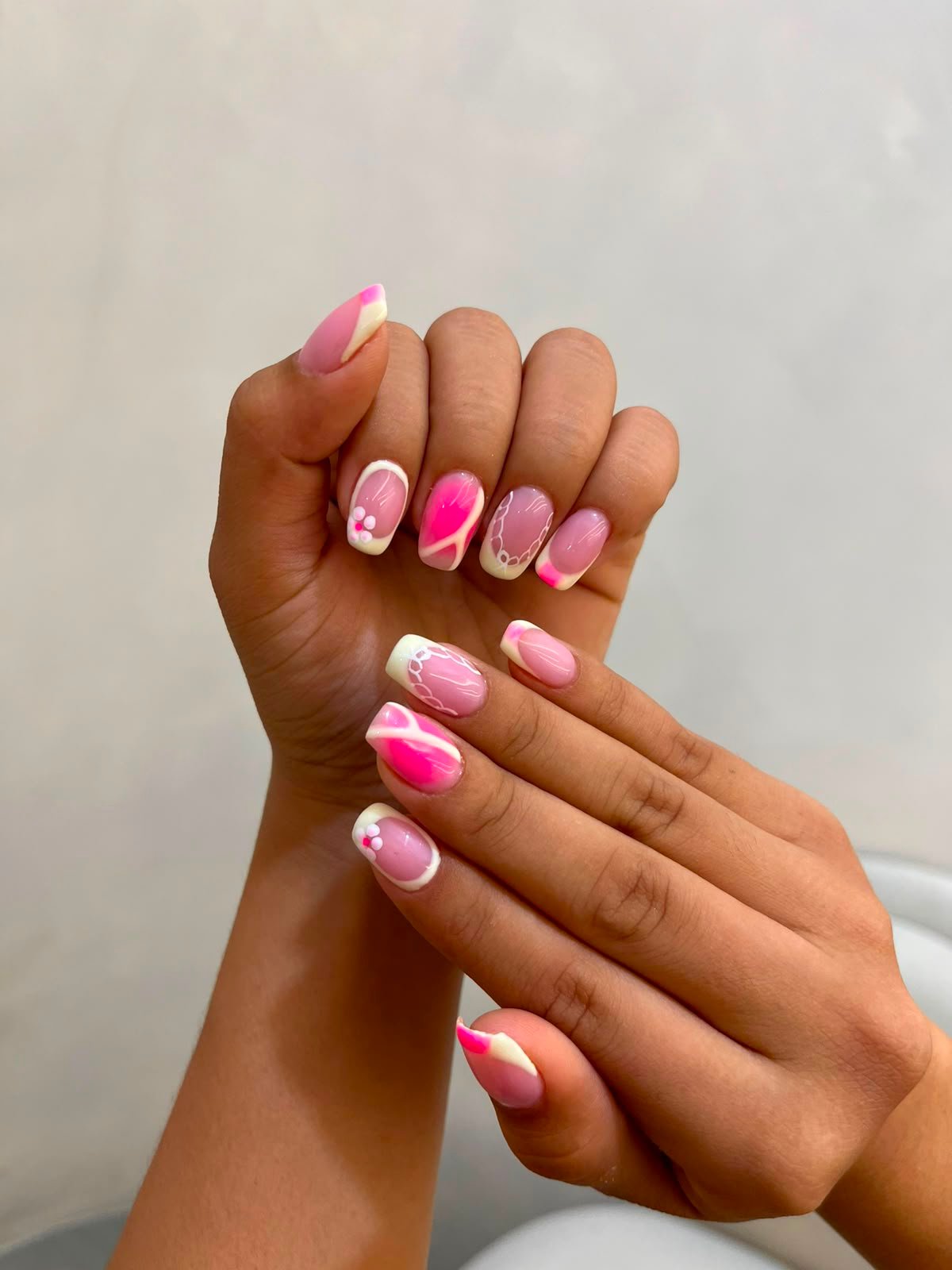 Uñas cuadradas con francés blanco y diseños en rosa fucsia, encaje y flores